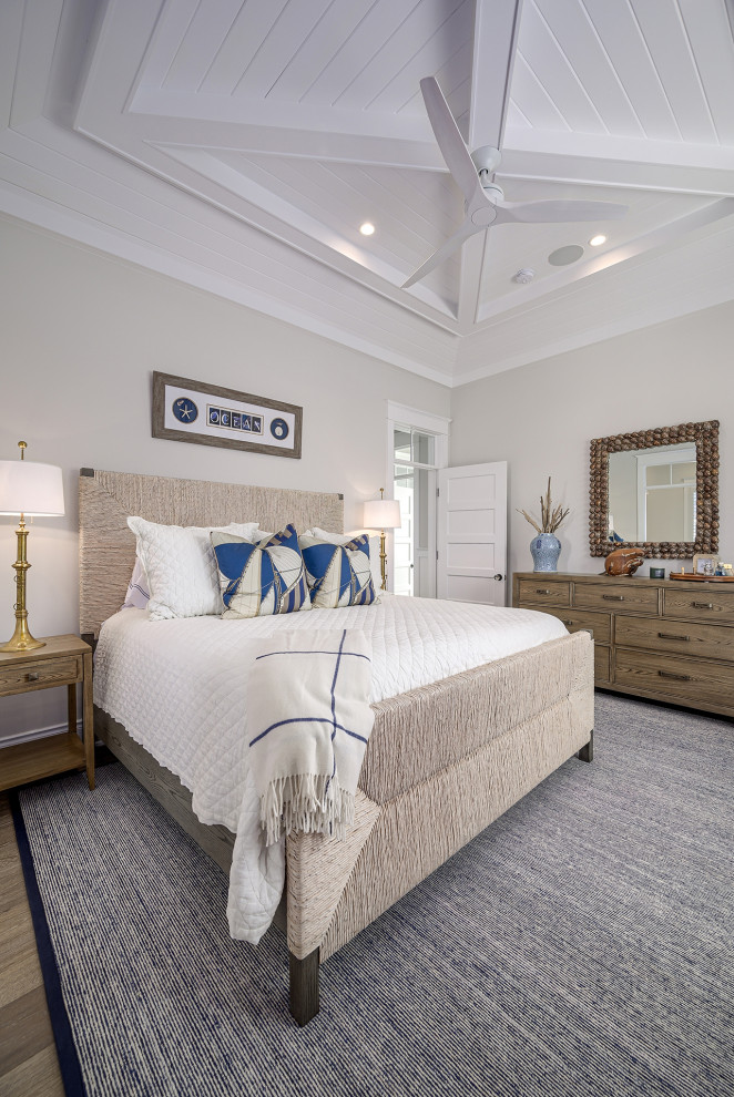 Foto di una camera degli ospiti stile marinaro con pareti beige, pavimento in legno massello medio, pavimento marrone e soffitto a volta