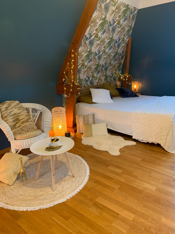 Mittelgroßes Schlafzimmer ohne Kamin, im Loft-Style mit blauer Wandfarbe, hellem Holzboden, braunem Boden, freigelegten Dachbalken und Tapetenwänden in Sonstige