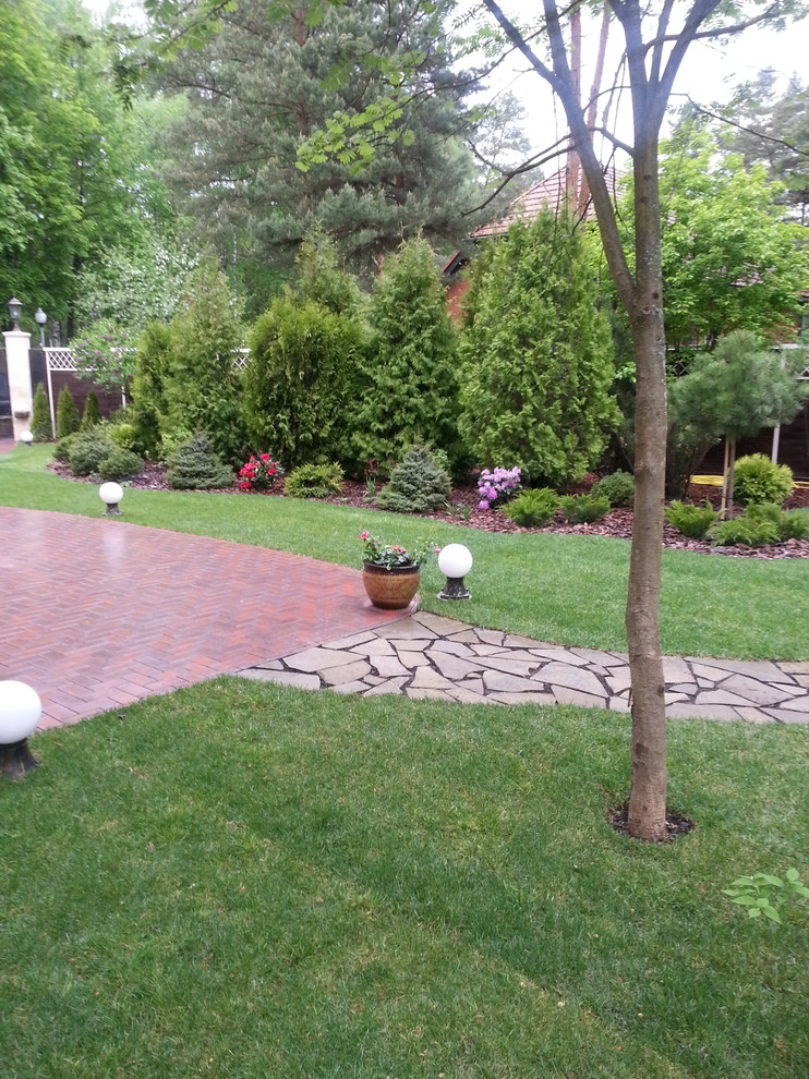 This is an example of a small traditional courtyard partial sun garden for spring in Moscow with brick pavers.