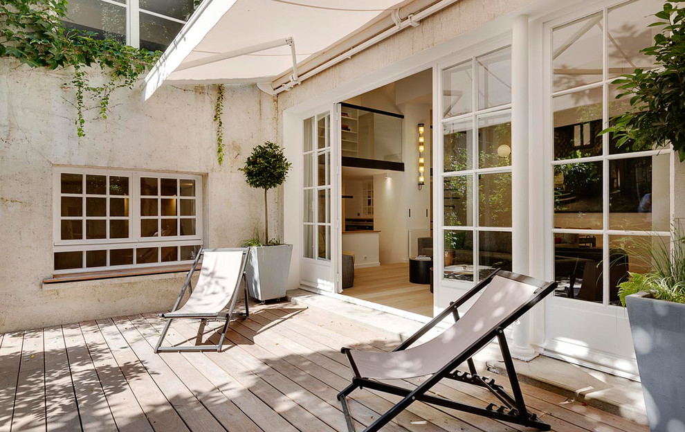 Design ideas for a mediterranean deck in Paris with a container garden and an awning.