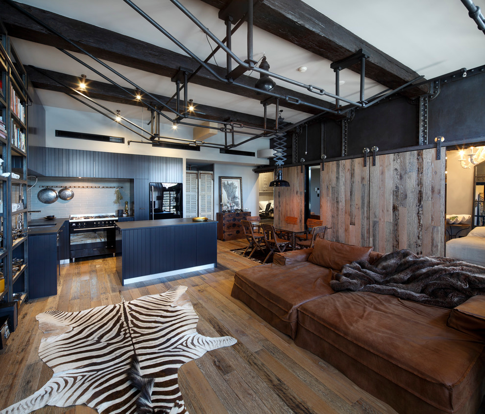 Mid-sized industrial open concept living room in Sydney with dark hardwood floors and black walls.