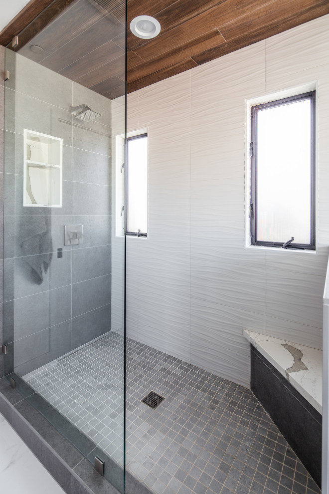 Photo of a large modern master bathroom in San Diego with flat-panel cabinets, brown cabinets, a double shower, gray tile, stone tile, white walls, porcelain floors, a drop-in sink, quartzite benchtops, white floor, a sliding shower screen, white benchtops, an enclosed toilet, a double vanity, a built-in vanity and wood.