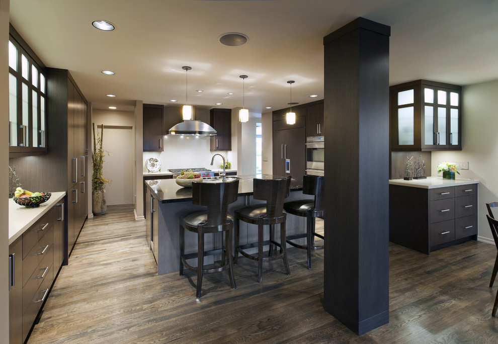 Photo of a contemporary u-shaped kitchen in Vancouver with flat-panel cabinets, dark wood cabinets and panelled appliances.