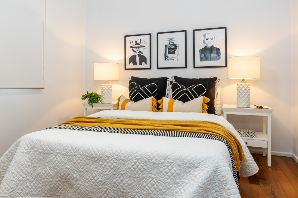 Contemporary bedroom in Brisbane with white walls, medium hardwood floors and brown floor.