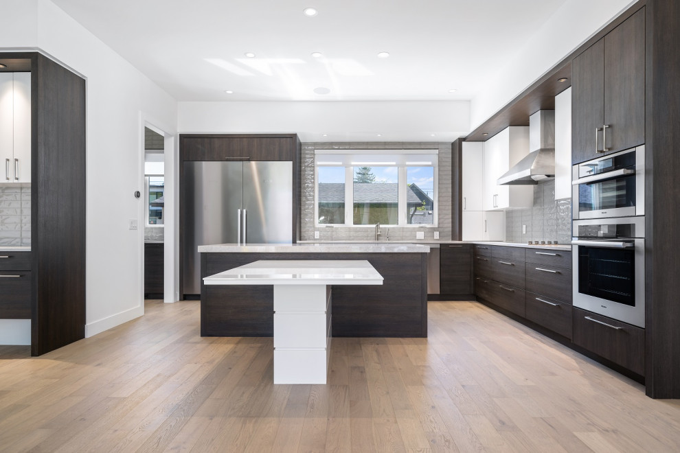 Mid-sized transitional l-shaped light wood floor and brown floor eat-in kitchen photo in Calgary with an undermount sink, shaker cabinets, dark wood cabinets, quartzite countertops, gray backsplash, ceramic backsplash, stainless steel appliances, an island and beige countertops