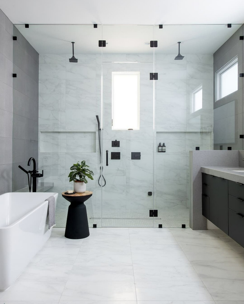 Exemple d'une salle de bain tendance avec un placard à porte plane, des portes de placard noires, une baignoire indépendante, un carrelage blanc, un lavabo encastré, un sol gris, un plan de toilette gris, une niche, meuble-lavabo suspendu, une douche double et une cabine de douche à porte battante.
