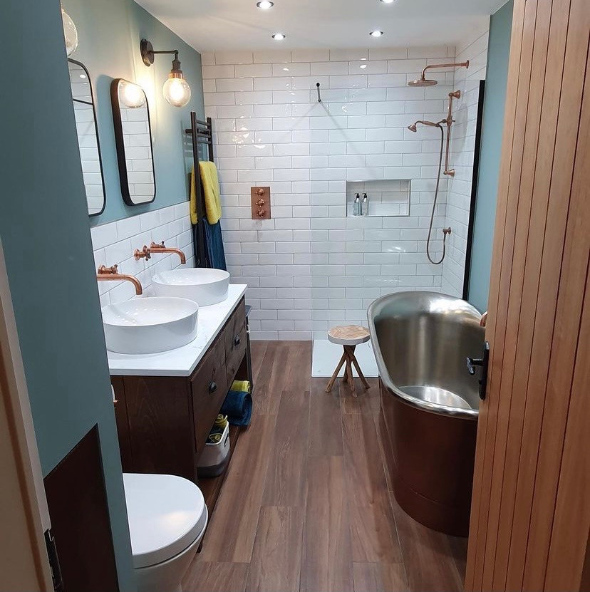 Photo of a small modern kids wet room bathroom in Other with brown cabinets, a freestanding tub, a one-piece toilet, white tile, subway tile, blue walls, wood-look tile, a pedestal sink, brown floor, an open shower, white benchtops, a double vanity and a freestanding vanity.