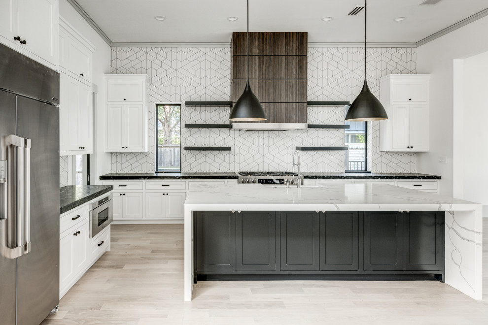 Open concept kitchen - transitional l-shaped light wood floor and white floor open concept kitchen idea in Dallas with a farmhouse sink, shaker cabinets, white cabinets, quartz countertops, white backsplash, ceramic backsplash, stainless steel appliances, an island and white countertops