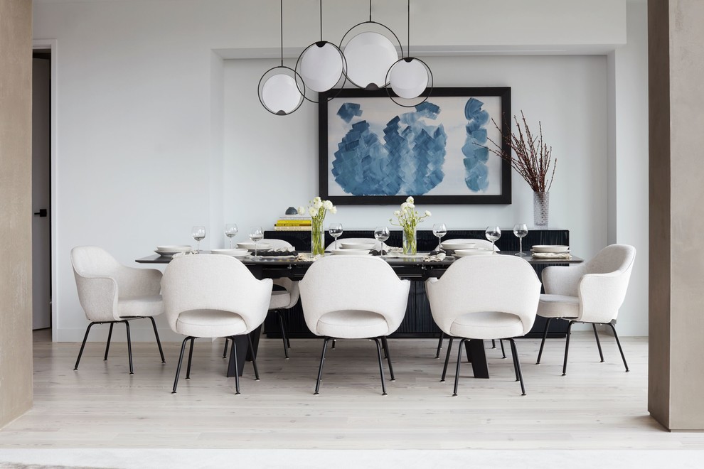 Contemporary dining room in New York with white walls, light hardwood floors, no fireplace and beige floor.
