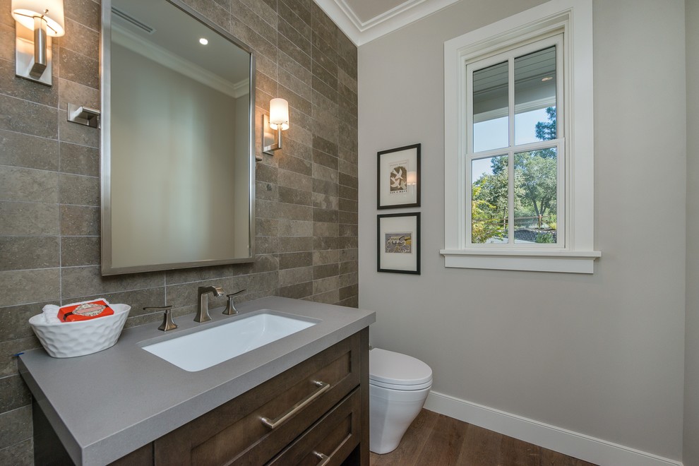 Inspiration for a small country 3/4 bathroom in San Francisco with shaker cabinets, dark wood cabinets, a one-piece toilet, brown tile, ceramic tile, grey walls, dark hardwood floors, an undermount sink, engineered quartz benchtops and brown floor.