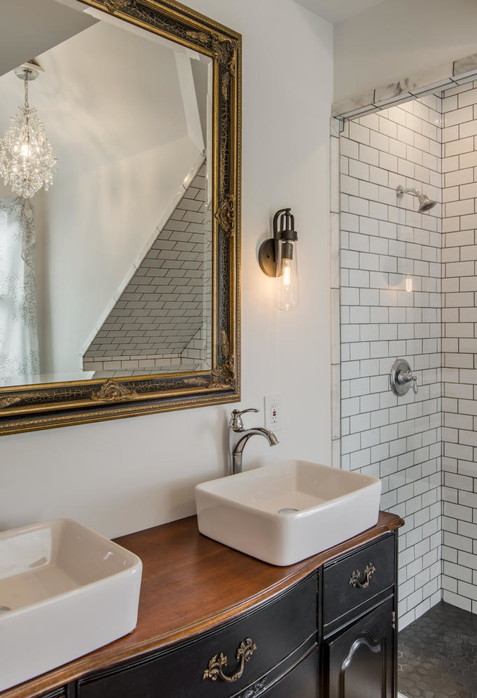 Design ideas for a mid-sized eclectic master bathroom in Nashville with a vessel sink, furniture-like cabinets, black cabinets, wood benchtops, a claw-foot tub, an alcove shower, a two-piece toilet, black and white tile, porcelain tile, white walls and porcelain floors.