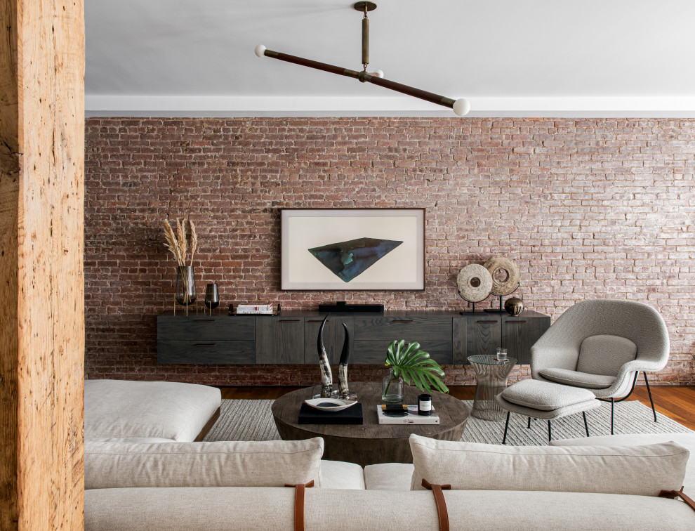 Large eclectic loft-style living room in New York with medium hardwood floors, a wall-mounted tv and brick walls.