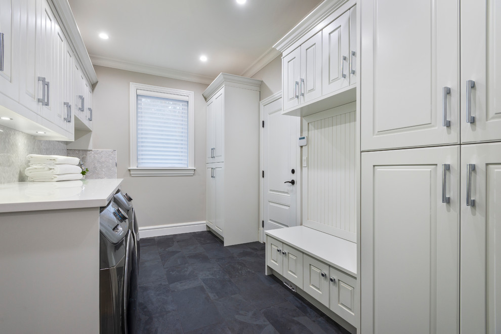 Mid-sized traditional single-wall utility room in Vancouver with an undermount sink, raised-panel cabinets, white cabinets, quartzite benchtops, grey walls, slate floors, a side-by-side washer and dryer, grey floor and white benchtop.