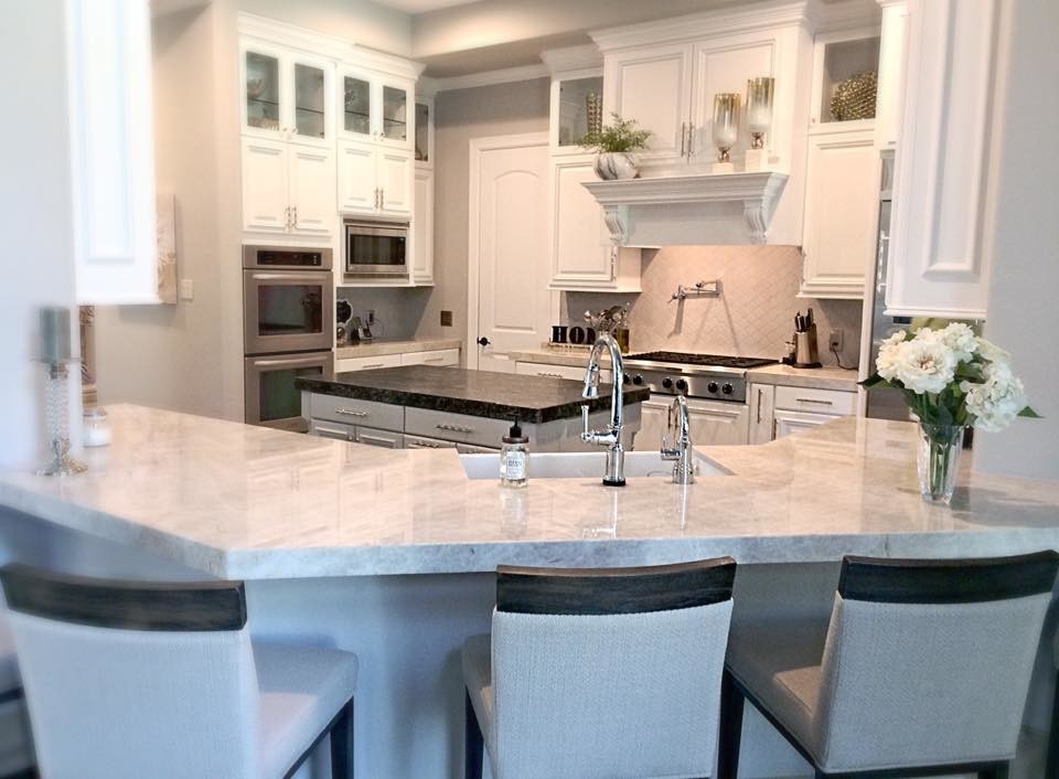 Example of a mid-sized transitional u-shaped slate floor eat-in kitchen design in Houston with a farmhouse sink, raised-panel cabinets, white cabinets, quartzite countertops, gray backsplash, porcelain backsplash, stainless steel appliances and an island