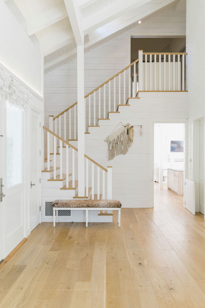 This is an example of a country wood u-shaped staircase in Los Angeles with wood risers, wood railing and planked wall panelling.