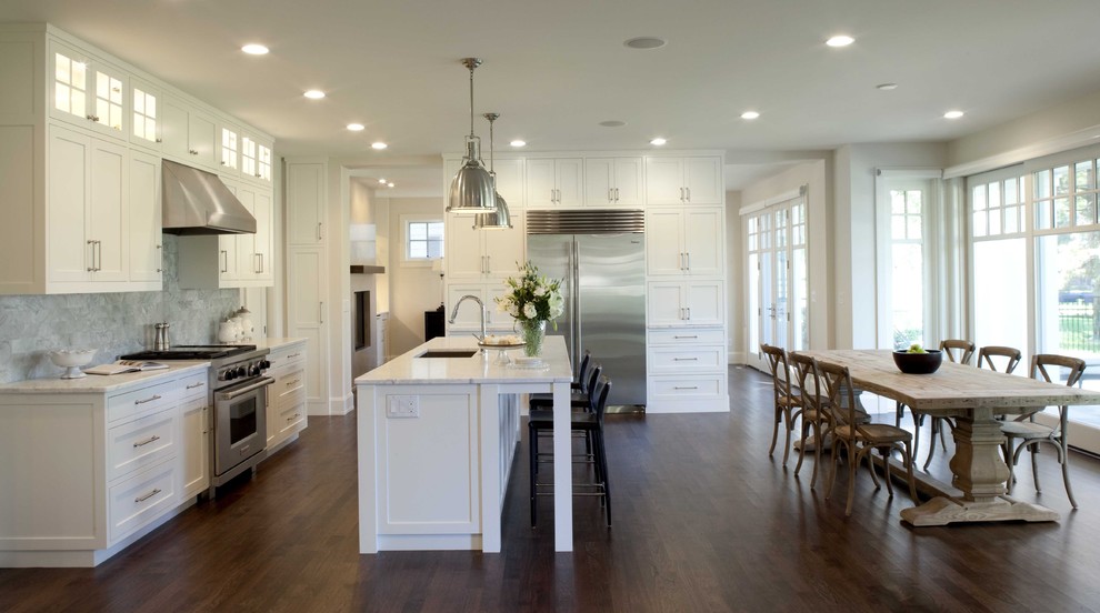Inspiration for a traditional eat-in kitchen in Minneapolis with stainless steel appliances, marble benchtops, white cabinets, grey splashback, stone tile splashback, an undermount sink, recessed-panel cabinets, dark hardwood floors and white benchtop.