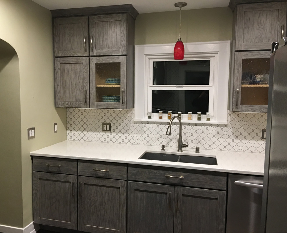 Enclosed kitchen - small transitional galley enclosed kitchen idea in Seattle with an undermount sink, shaker cabinets, gray cabinets, quartzite countertops, white backsplash, ceramic backsplash, stainless steel appliances and no island
