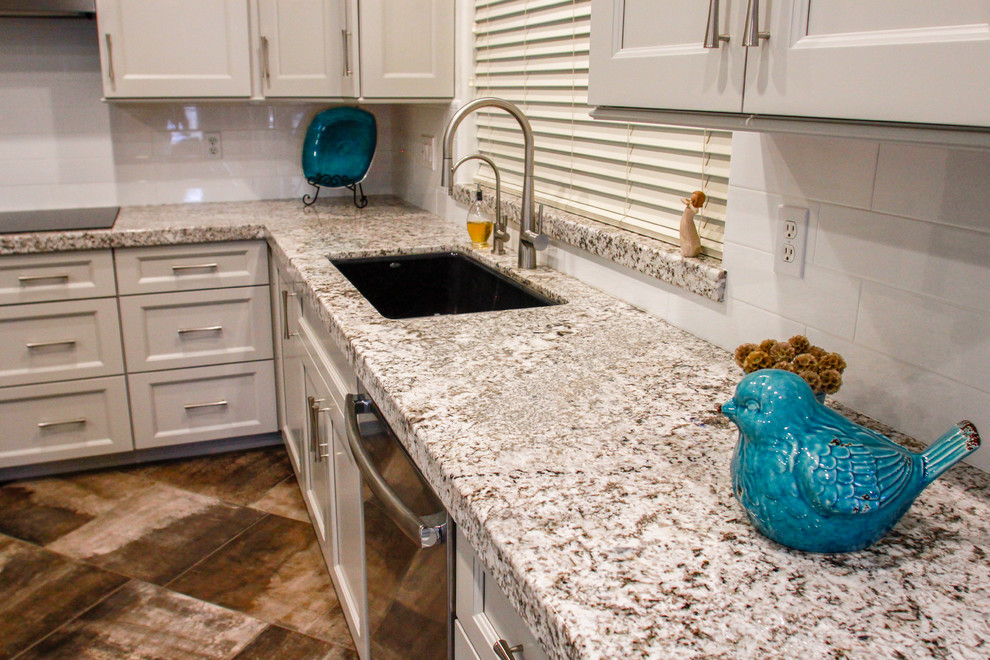 Example of a mid-sized transitional u-shaped porcelain tile and gray floor eat-in kitchen design in Phoenix with a double-bowl sink, shaker cabinets, gray cabinets, granite countertops, white backsplash, subway tile backsplash, stainless steel appliances, an island and white countertops