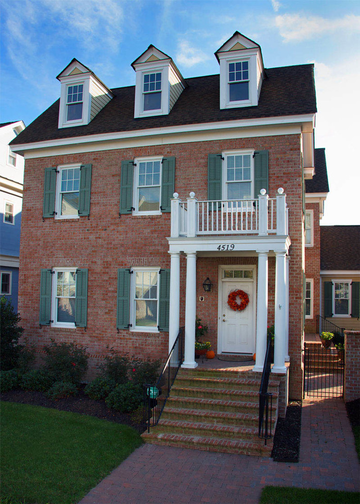 Design ideas for a mid-sized traditional two-storey brick red exterior in Other with a gable roof.