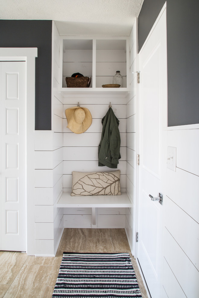 This is an example of a contemporary mudroom with black walls and planked wall panelling.