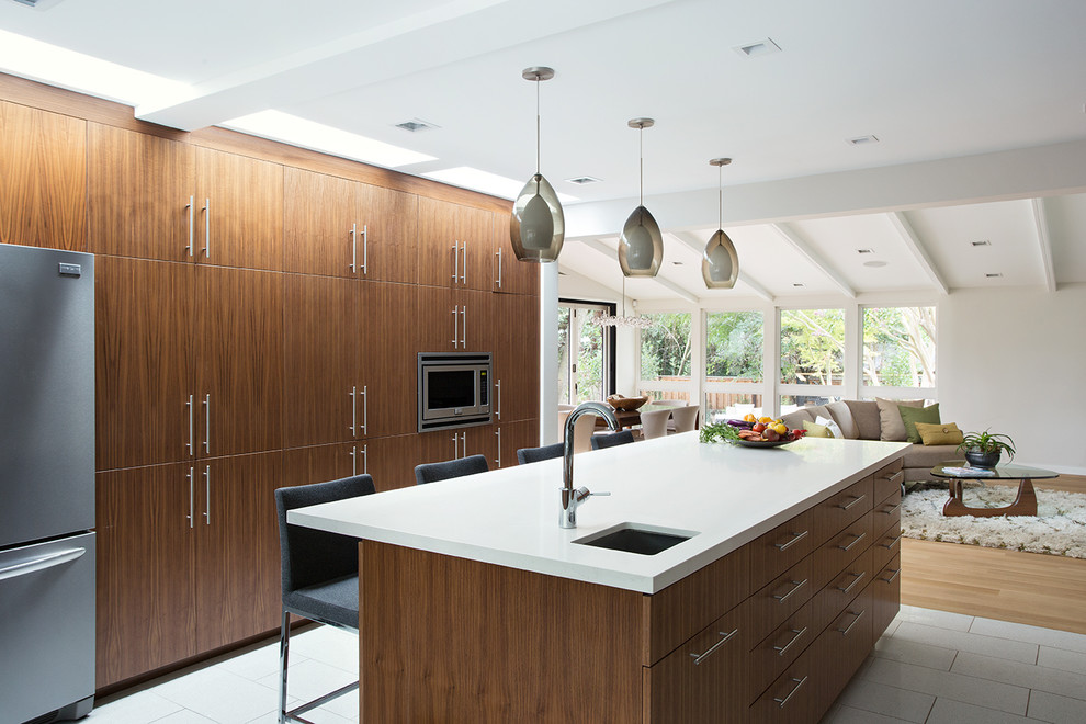 Design ideas for a midcentury galley open plan kitchen in San Francisco with an undermount sink, flat-panel cabinets, dark wood cabinets, stainless steel appliances and with island.