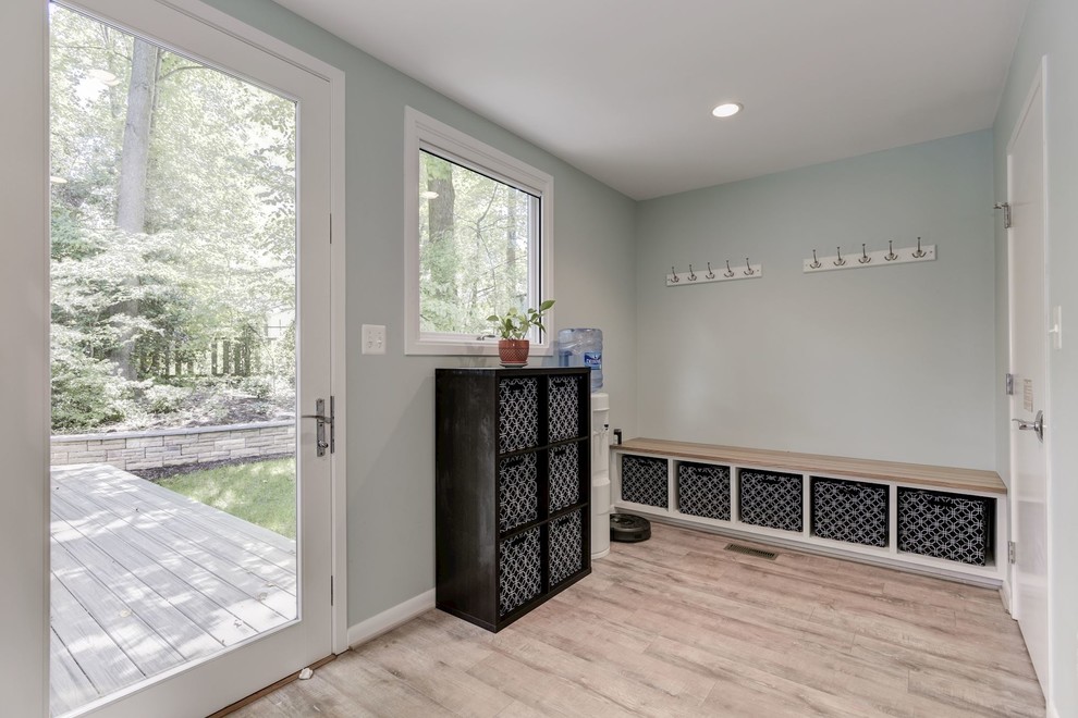 Mid-sized transitional light wood floor and brown floor mudroom photo in DC Metro with gray walls and a glass front door