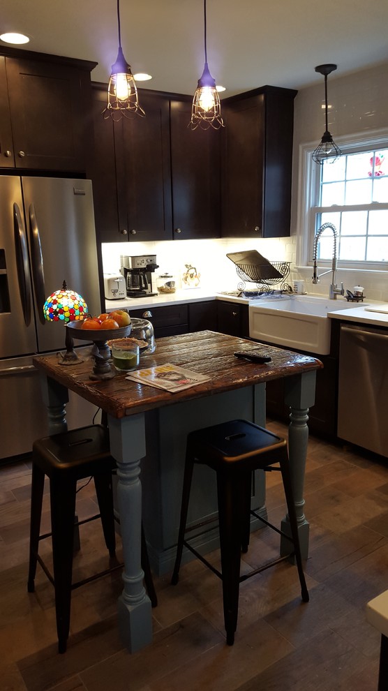 Eat-in kitchen - mid-sized rustic u-shaped porcelain tile eat-in kitchen idea in Indianapolis with a farmhouse sink, shaker cabinets, dark wood cabinets, wood countertops, white backsplash, ceramic backsplash, stainless steel appliances and an island