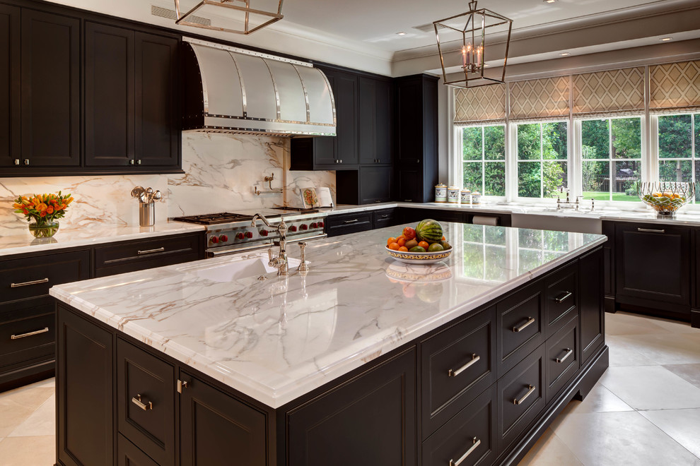 Photo of a separate kitchen in Houston with a farmhouse sink, recessed-panel cabinets, dark wood cabinets, marble benchtops, stainless steel appliances, ceramic floors and multiple islands.