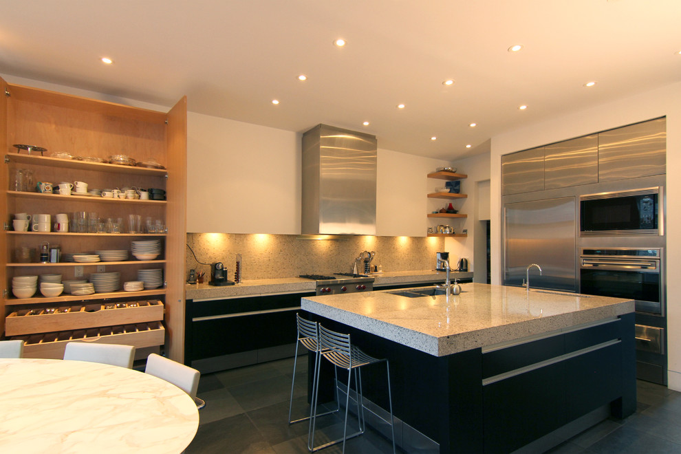 Example of a minimalist l-shaped eat-in kitchen design in Toronto with stainless steel cabinets, beige backsplash, stainless steel appliances, a double-bowl sink and flat-panel cabinets