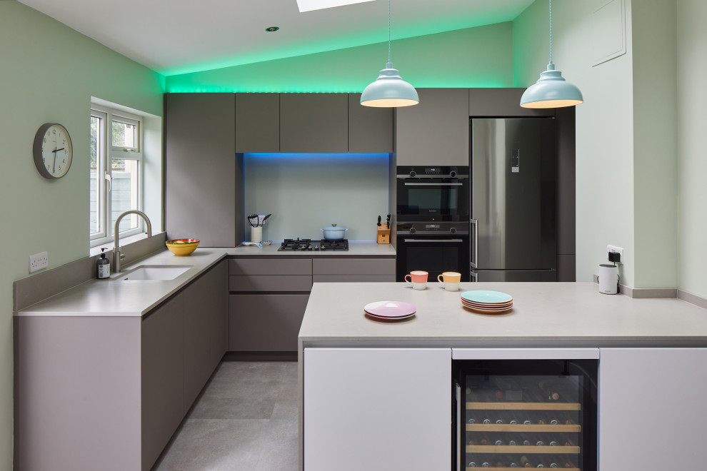 Design ideas for a mid-sized contemporary l-shaped eat-in kitchen in London with an undermount sink, flat-panel cabinets, grey cabinets, quartz benchtops, glass sheet splashback, stainless steel appliances and with island.