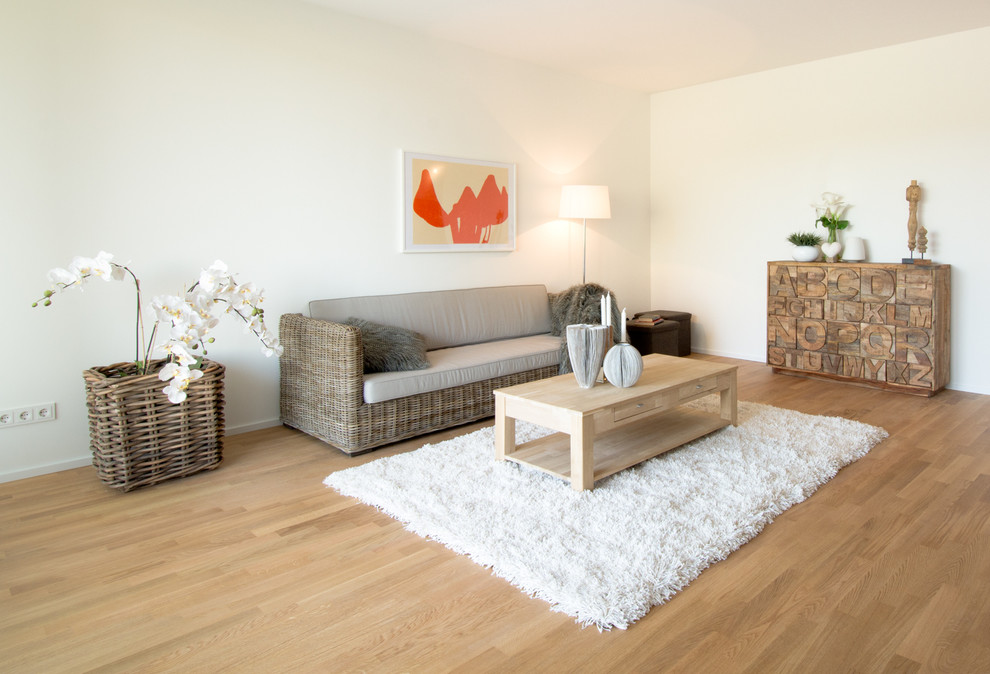This is an example of a mid-sized contemporary family room in Essen with white walls and medium hardwood floors.