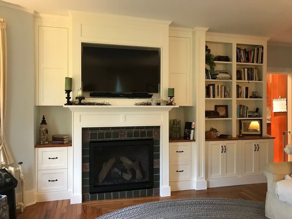 Mid-sized transitional family room in Philadelphia with grey walls, medium hardwood floors, a standard fireplace, a tile fireplace surround, a built-in media wall and brown floor.