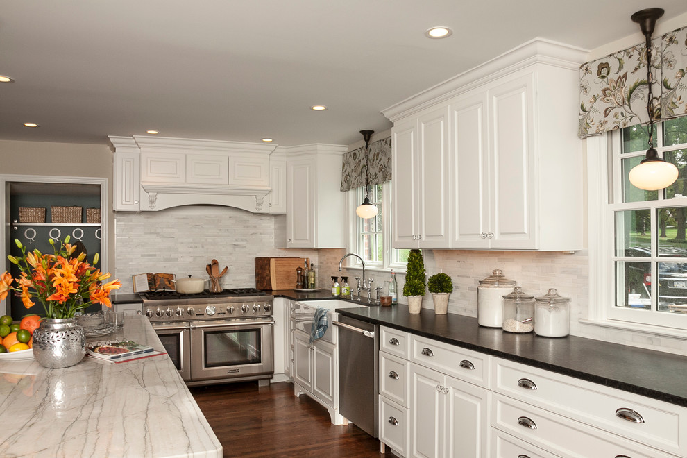 Large transitional u-shaped medium tone wood floor eat-in kitchen photo in Philadelphia with raised-panel cabinets, quartzite countertops, white backsplash, stone tile backsplash, stainless steel appliances, a peninsula, a farmhouse sink and white cabinets