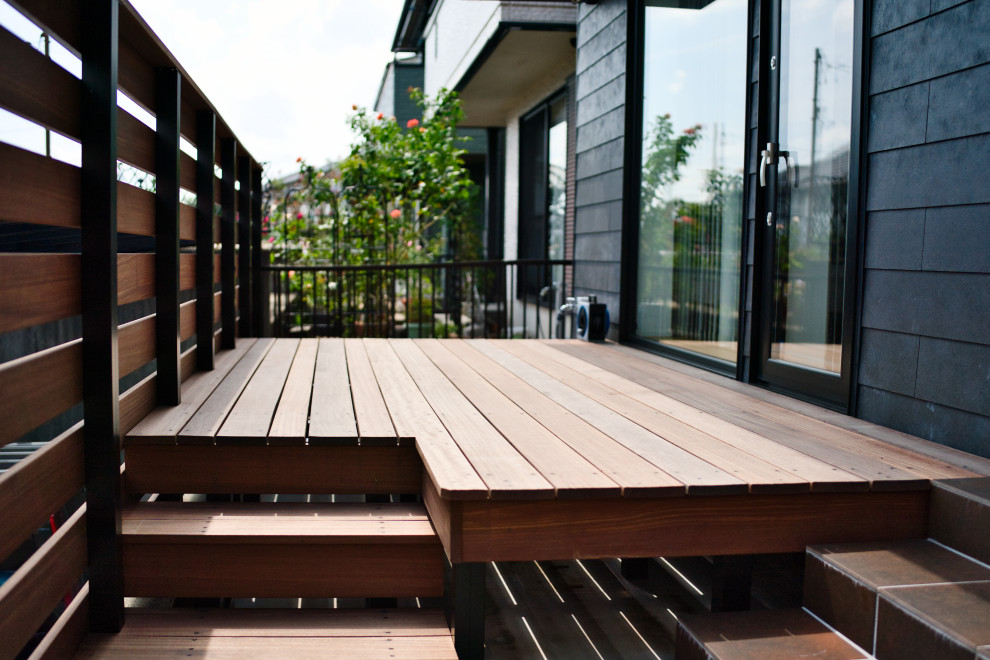 Foto på en liten minimalistisk terrass längs med huset, med räcke i metall
