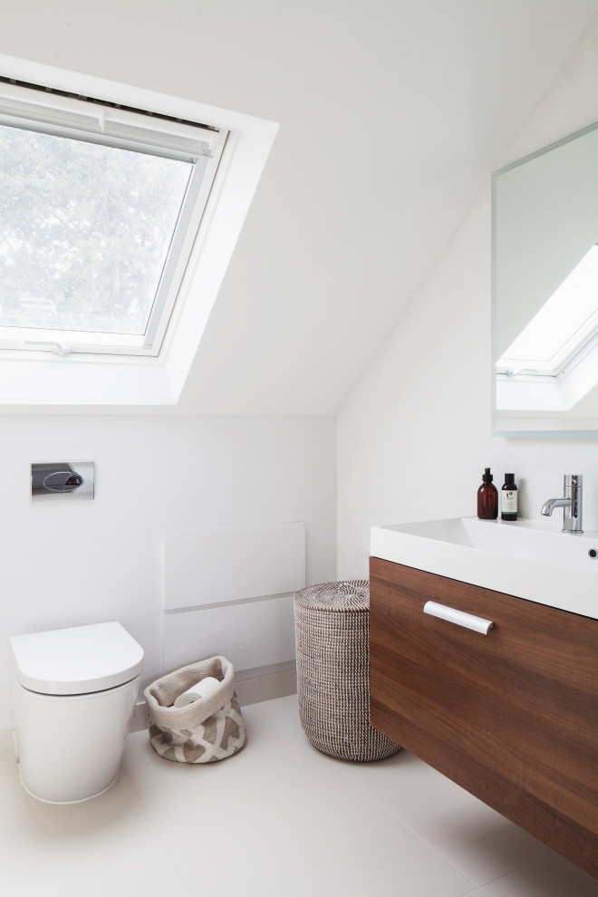 Inspiration for a small scandinavian master bathroom in Sussex with flat-panel cabinets, dark wood cabinets, an open shower, white tile, ceramic tile, an integrated sink, solid surface benchtops, an open shower, white benchtops, a single vanity, a floating vanity, a one-piece toilet, ceramic floors, beige floor and an enclosed toilet.