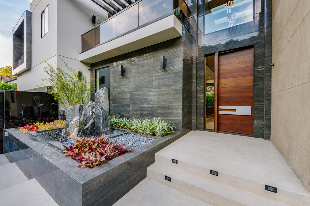 Photo of an expansive contemporary courtyard full sun xeriscape in Los Angeles with a water feature.