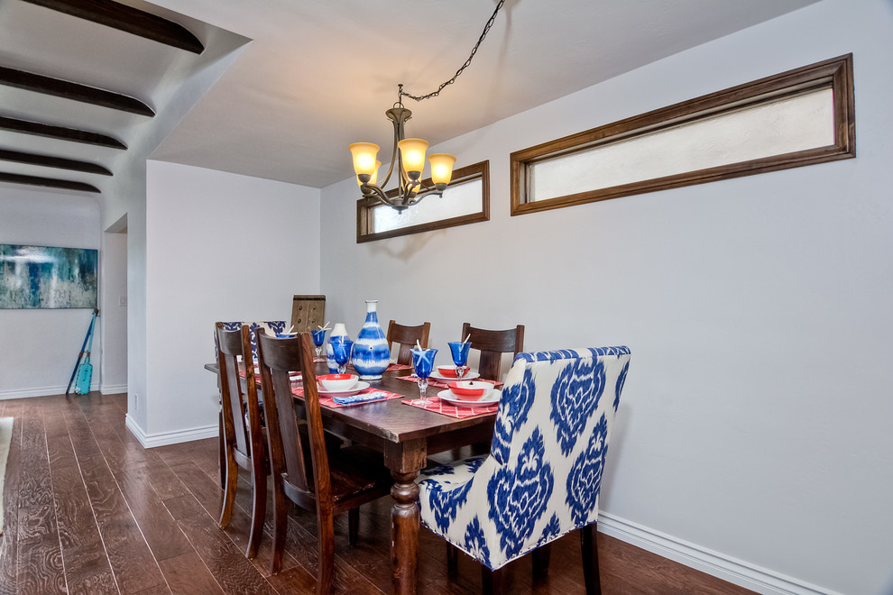 Small open plan dining in San Diego with white walls, medium hardwood floors and no fireplace.
