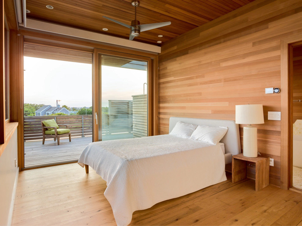 Cette photo montre une chambre parentale bord de mer en bois avec un sol en bois brun et un plafond en bois.