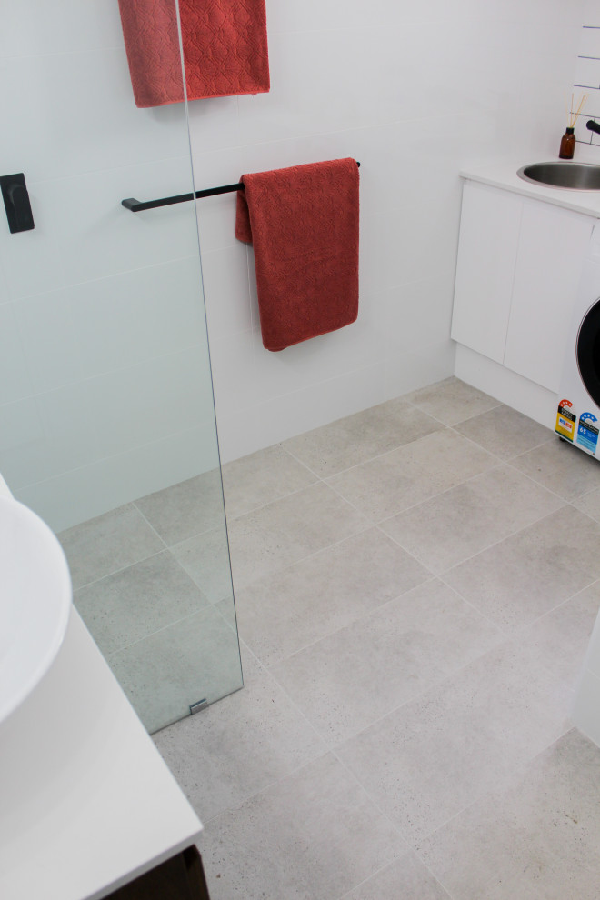 Large modern kids bathroom in Perth with flat-panel cabinets, dark wood cabinets, an open shower, a one-piece toilet, white tile, ceramic tile, white walls, porcelain floors, a vessel sink, engineered quartz benchtops, grey floor, an open shower and white benchtops.