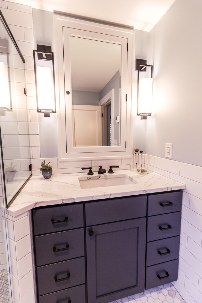 Photo of a large transitional master bathroom in Minneapolis with flat-panel cabinets, blue cabinets, a corner shower, a one-piece toilet, white tile, subway tile, grey walls, an undermount sink, engineered quartz benchtops, a hinged shower door and beige benchtops.