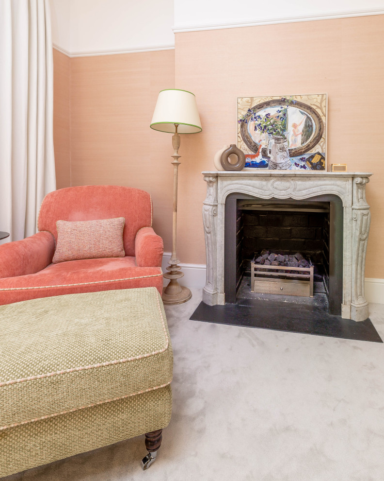 Inspiration for a large eclectic master bedroom in London with pink walls, carpet, a standard fireplace, a wood fireplace surround, grey floor and wallpaper.