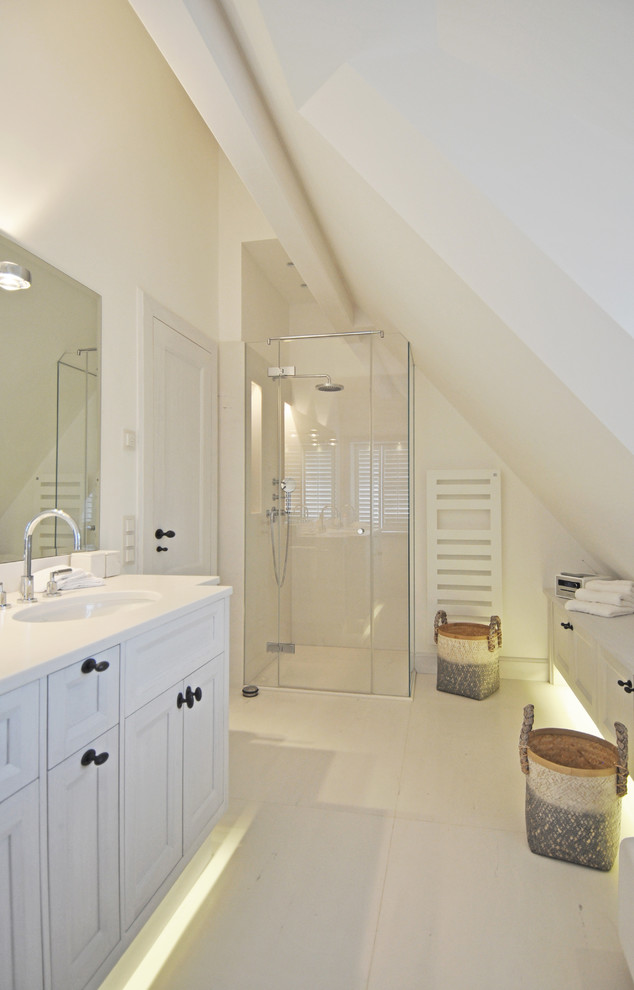 Mittelgroßes Maritimes Duschbad mit Schrankfronten im Shaker-Stil, weißen Schränken, bodengleicher Dusche, weißer Wandfarbe, integriertem Waschbecken, beigem Boden und Falttür-Duschabtrennung in Sonstige