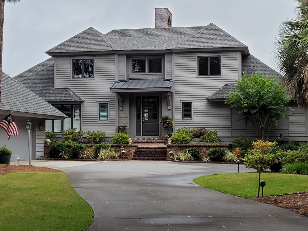 Ejemplo de fachada de casa gris y gris tradicional de tamaño medio de dos plantas con revestimiento de madera, tejado a cuatro aguas, tejado de teja de madera y tablilla