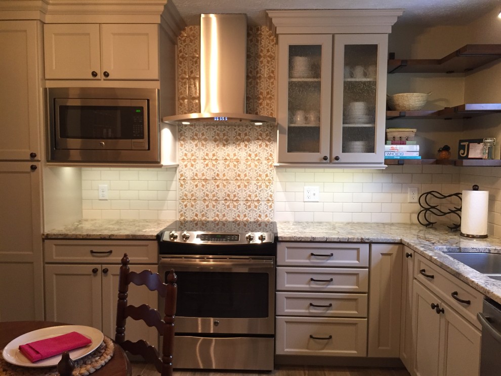 Kitchen - rustic brown floor kitchen idea in Cincinnati with a double-bowl sink, raised-panel cabinets, beige cabinets, granite countertops, white backsplash, terra-cotta backsplash and stainless steel appliances