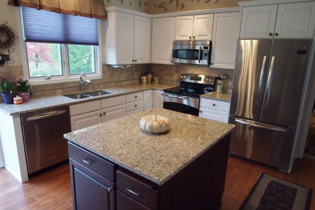 Photo of a traditional kitchen in Grand Rapids with an undermount sink, granite benchtops, beige splashback, ceramic splashback and stainless steel appliances.