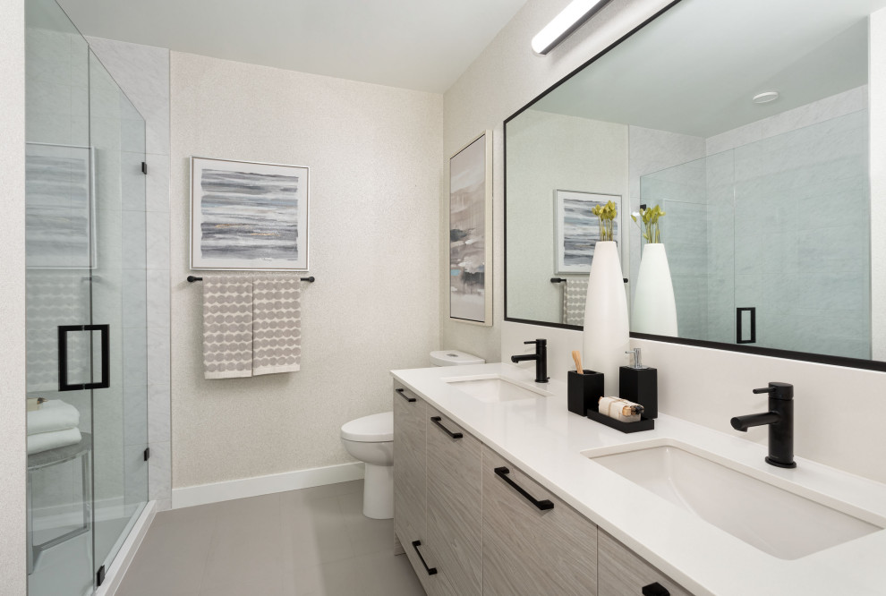 Photo of a small contemporary kids bathroom in Vancouver with flat-panel cabinets, brown cabinets, an alcove shower, a two-piece toilet, white tile, ceramic tile, white walls, porcelain floors, an undermount sink, quartzite benchtops, beige floor, a hinged shower door and white benchtops.