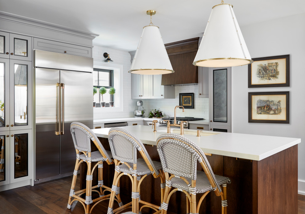 Example of a small transitional l-shaped dark wood floor and brown floor eat-in kitchen design in Toronto with gray cabinets, solid surface countertops, white backsplash, porcelain backsplash, stainless steel appliances, an island, white countertops, an undermount sink and recessed-panel cabinets