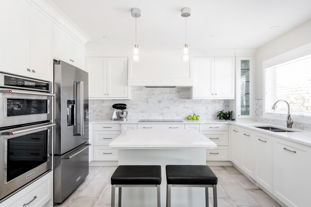 Design ideas for a mid-sized transitional u-shaped eat-in kitchen in Other with a double-bowl sink, shaker cabinets, quartz benchtops, multi-coloured splashback, subway tile splashback, stainless steel appliances, porcelain floors, with island, beige floor and white benchtop.