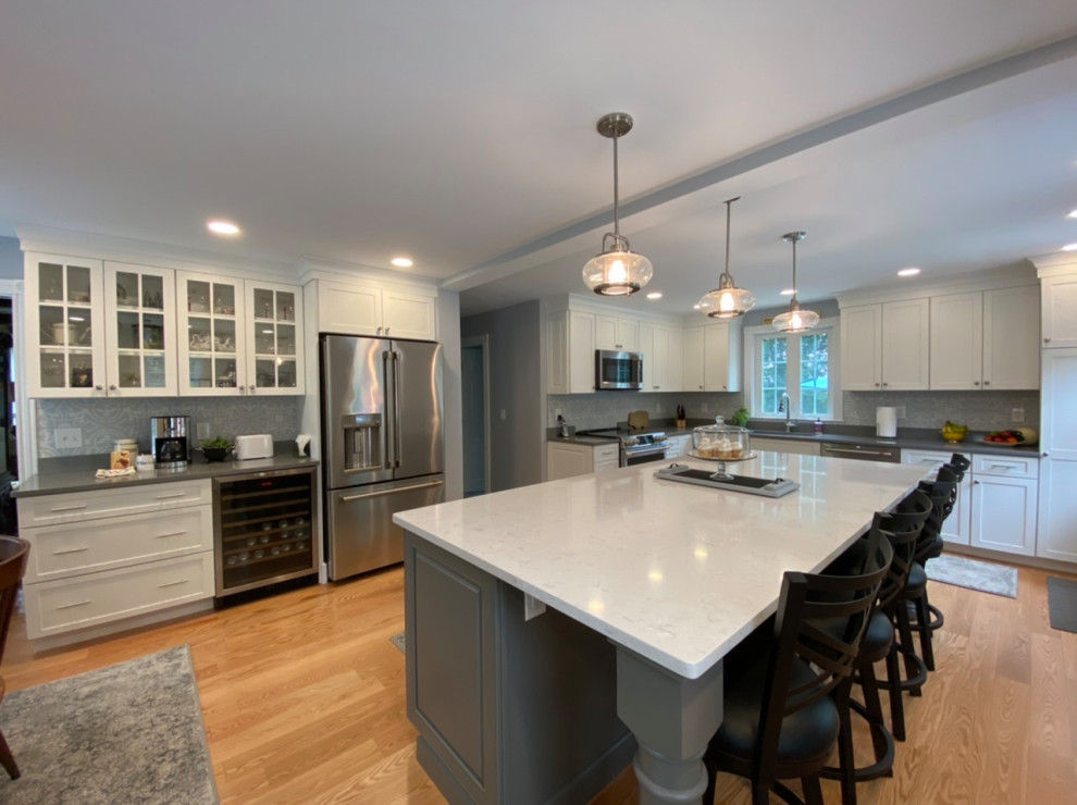 Inspiration for a mid-sized transitional eat-in kitchen remodel in Providence with flat-panel cabinets, quartz countertops and an island
