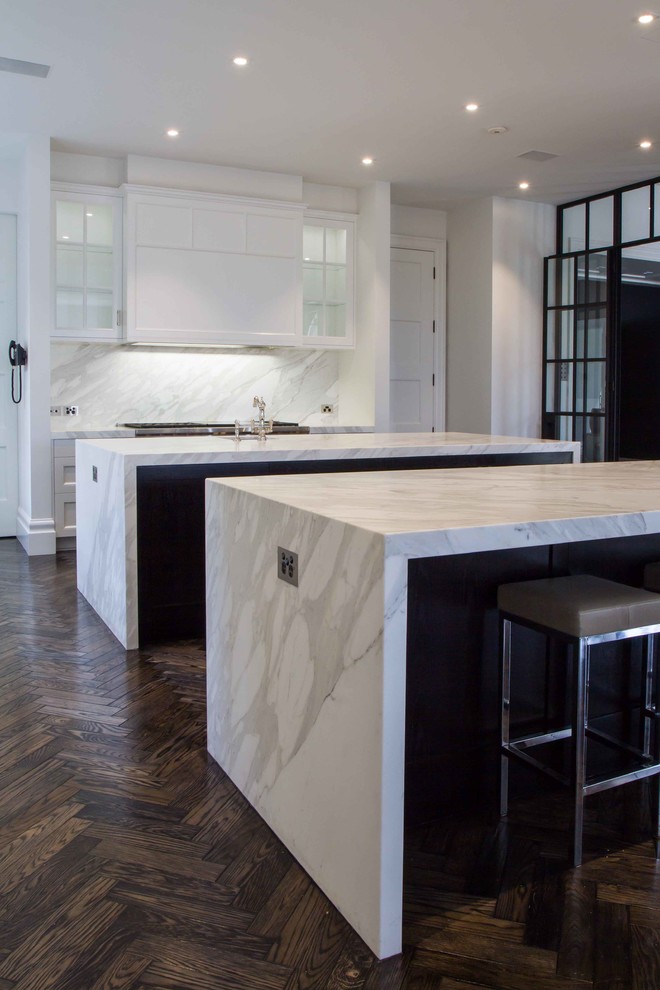 Photo of a large traditional l-shaped open plan kitchen in Melbourne with shaker cabinets, marble benchtops, stone slab splashback, dark hardwood floors and multiple islands.